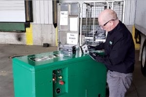 Employee feeds a hard drive into shredding machine