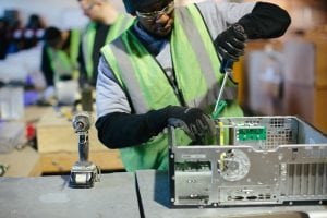 A Tech Dump employee dismantles a computer.