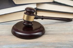 Court gavel on table with books.