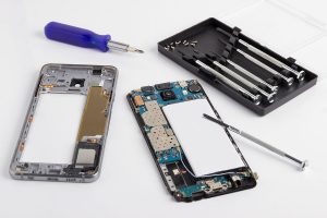 A smartphone being repaired with tools.