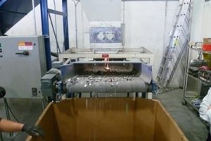 Sparks from shredding hard drives and material advancing down a conveyor to a collection box.