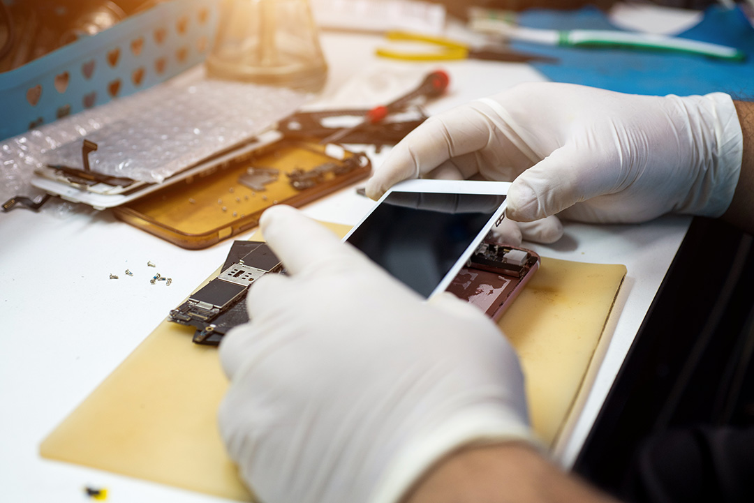 A technician works on repairing an iPhone.
