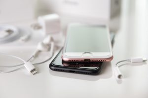 Two iPhones and accessories on a desk.