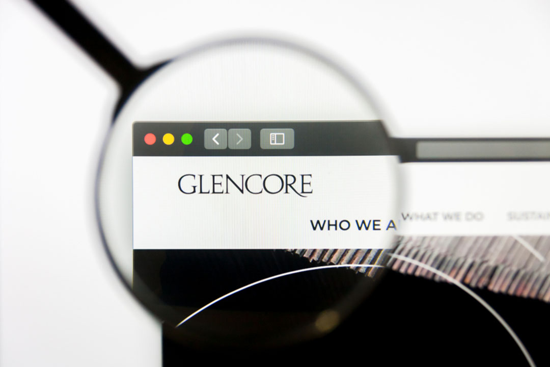 Glencore logo on screen under magnifying glass.