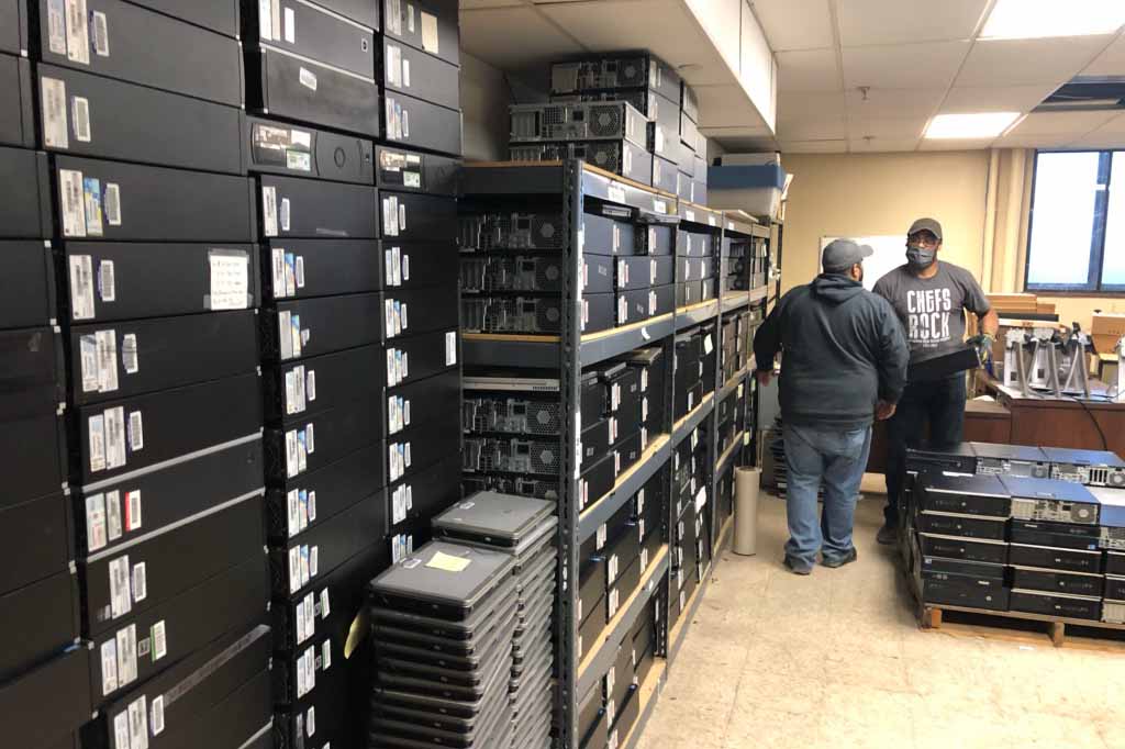 PCs for People employees picking up electronics from storage.