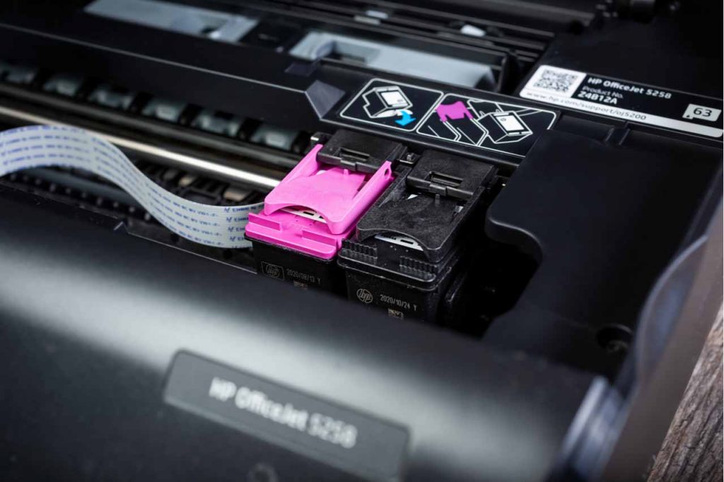 Closeup of printer cartridges inside an HP printer.
