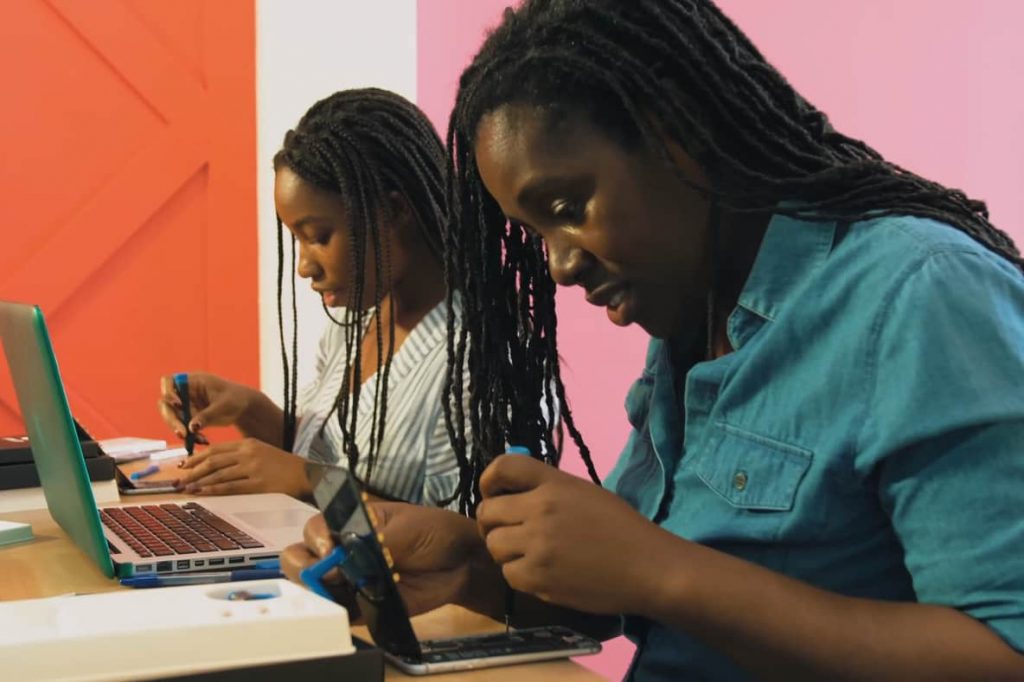 Two young women repairing their smartphones from the film Silicon Mountain