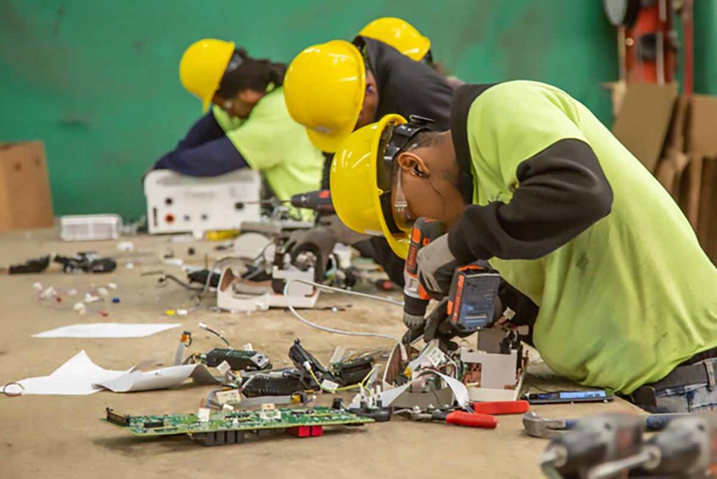 Employees at the RecycleForce facility dismantle electronics.