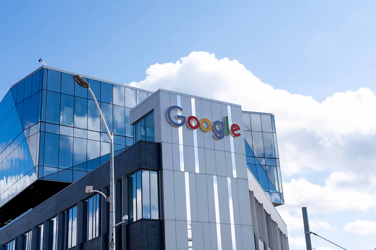 Google sign on company building with blue sky and clouds above.