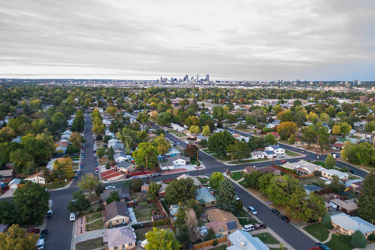 Aerial view of a Denver neighborhood with city skyline in background.