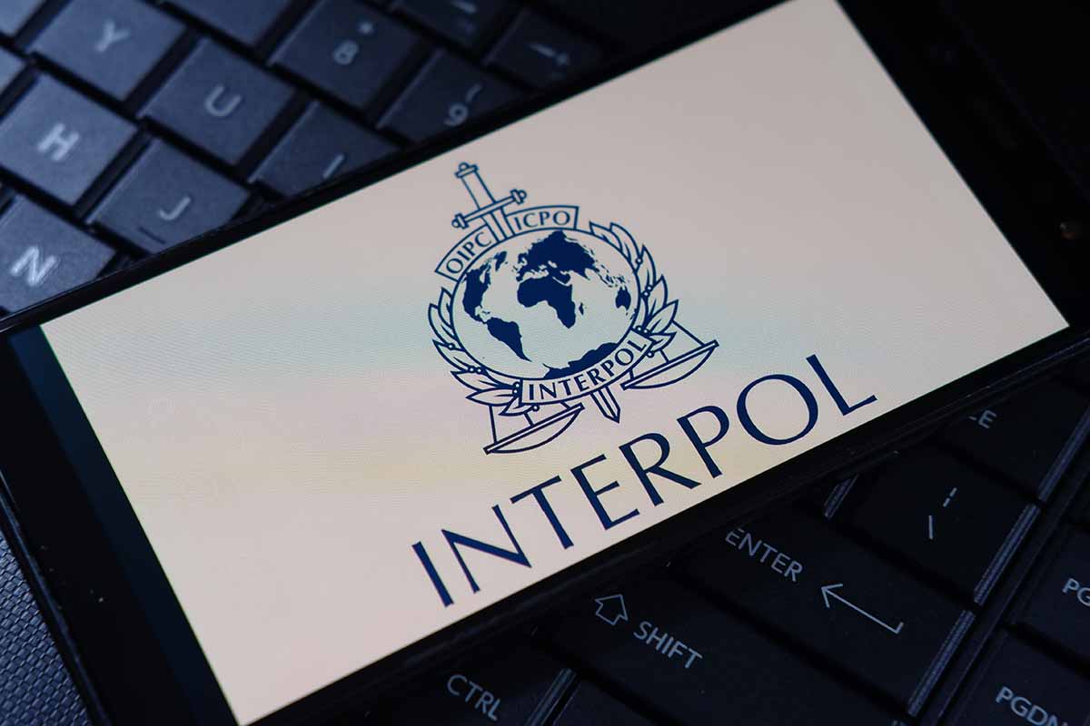 Interpol logo on phone, resting on a keyboard.