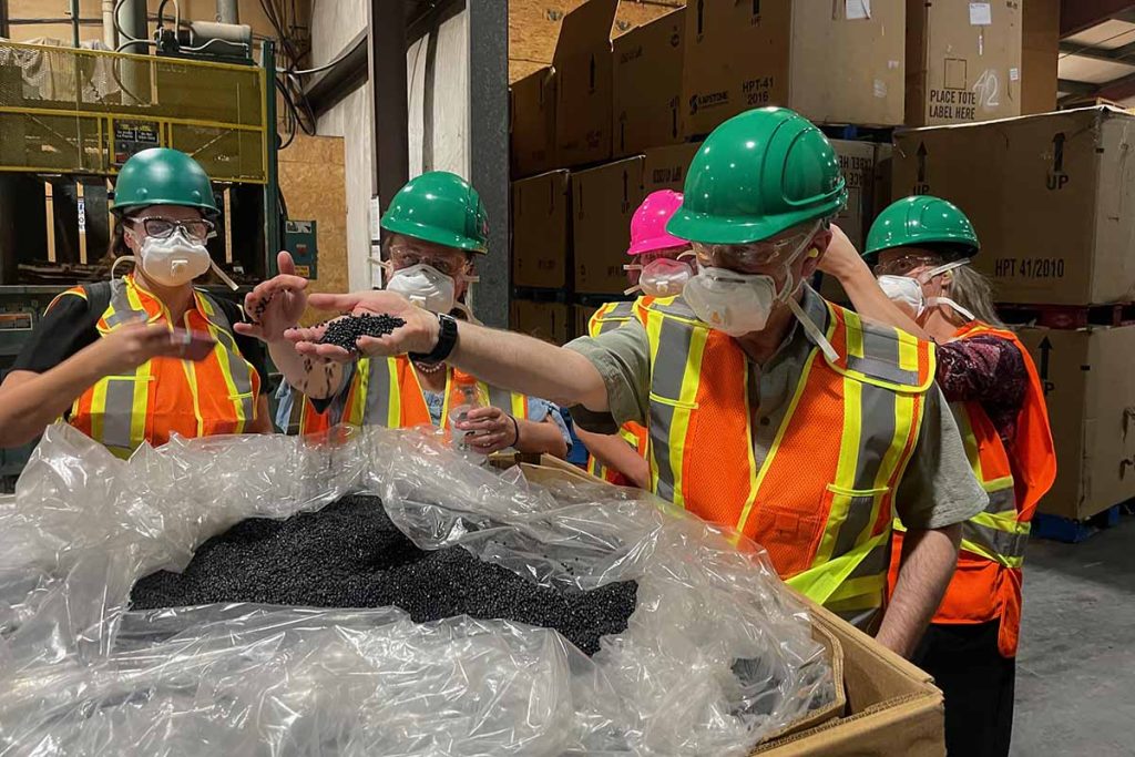Employees of KC Recycling handle PP pellets the company has processed.