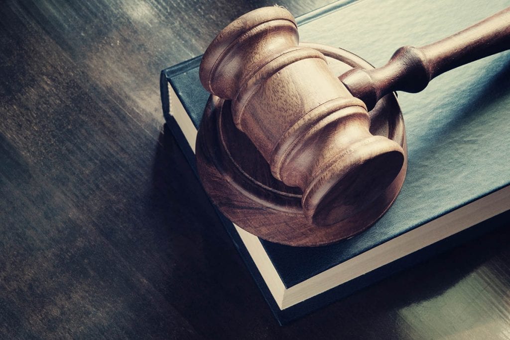 A gavel and a book on a table.