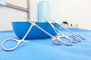 Close up of medical equipment on blue plastic sheeting and tray.