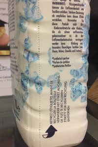 Deseaming shrink label on a P&G product bottle.