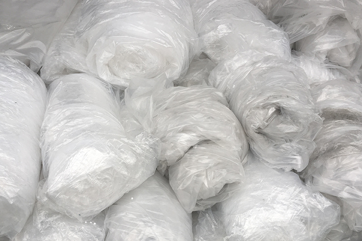 Stacks of rolled plastic film for recycling.