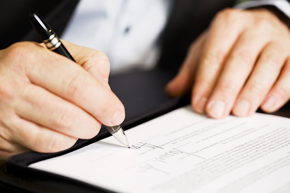 A person signing business documents.