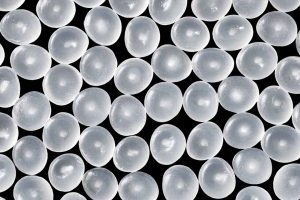Close up of plastic pellets on a black background.