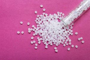 Resins spilled out of a tube onto a pink background.