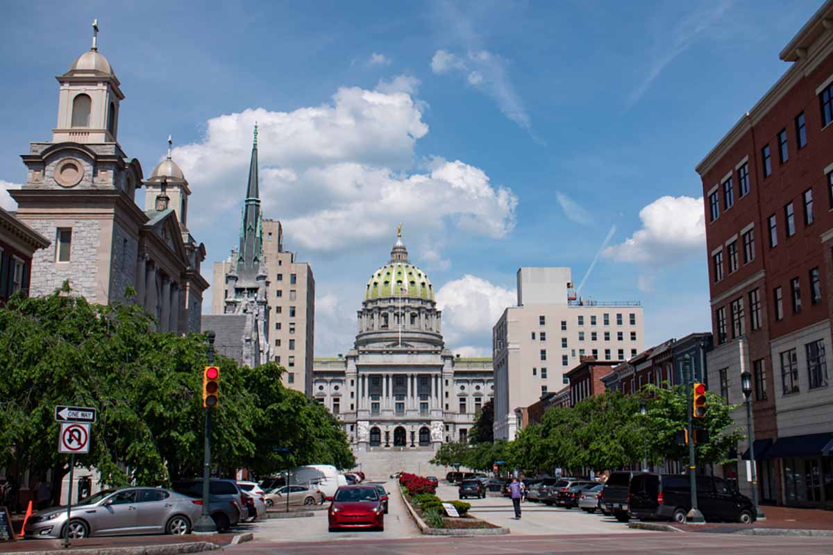 Pennsylvania state capitol building with surrounding architecture and city activity.