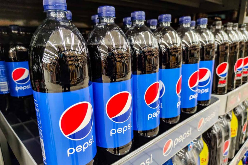 Row of Pepsi bottles on a supermarket shelf.