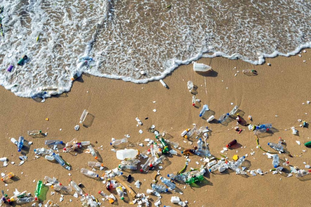 Plastics waste on a beach seen from above.