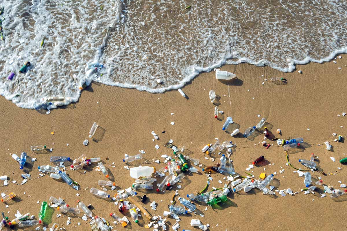 Plastics waste on a beach seen from above.