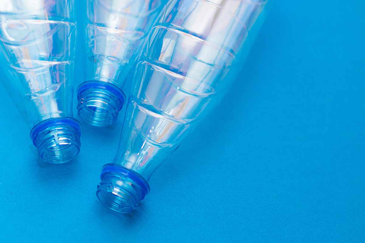 Empty PET drink bottles on a blue background.