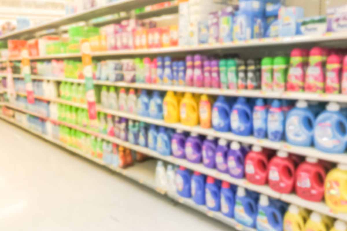 Blurred view of store shelf with laundry detergent products.