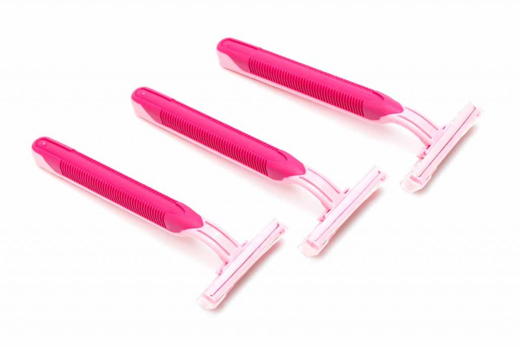 Pink disposable razors on white background.