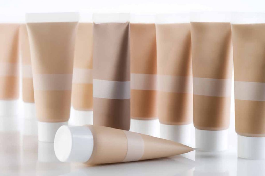 Many plastic cosmetic tubes against a white background.