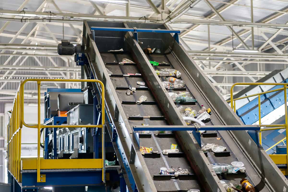 Material on a conveyor inside a sorting and processing facility.