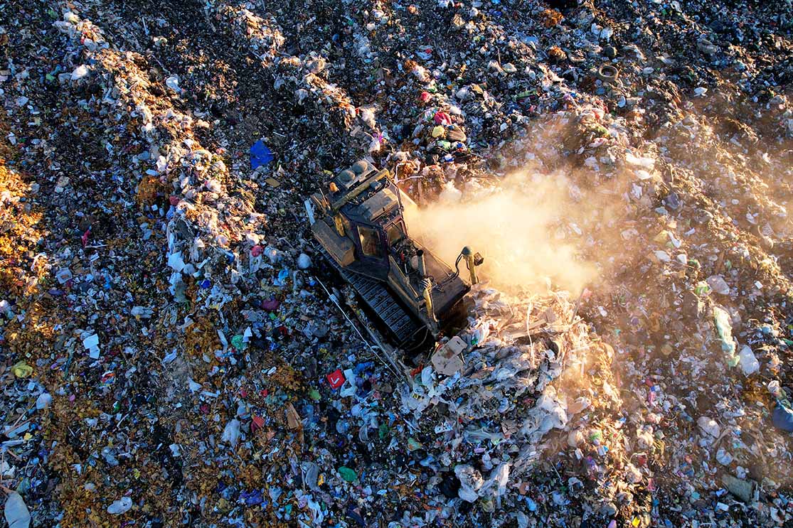 Landfill seen from above with equipment moving materials.