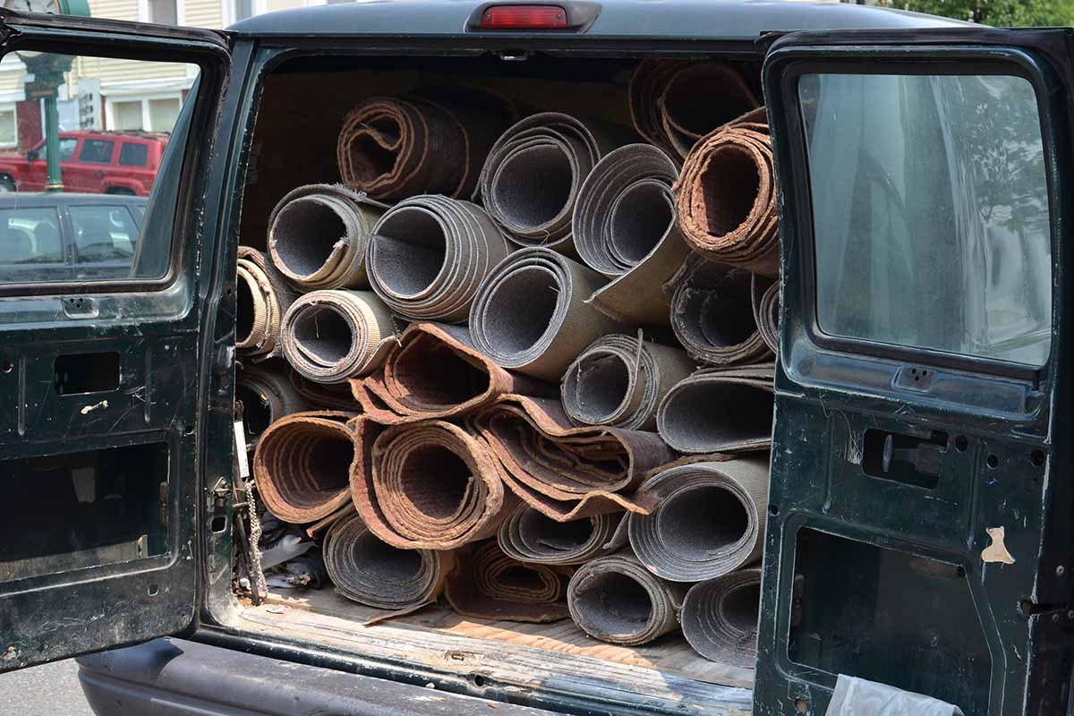 Van filled with rolled carpeting for recycling or disposal.