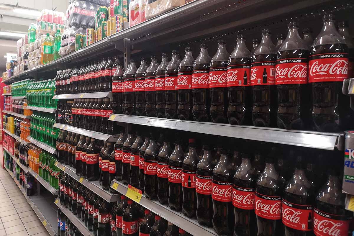 Grocery store aisle with Coca-Cola products.