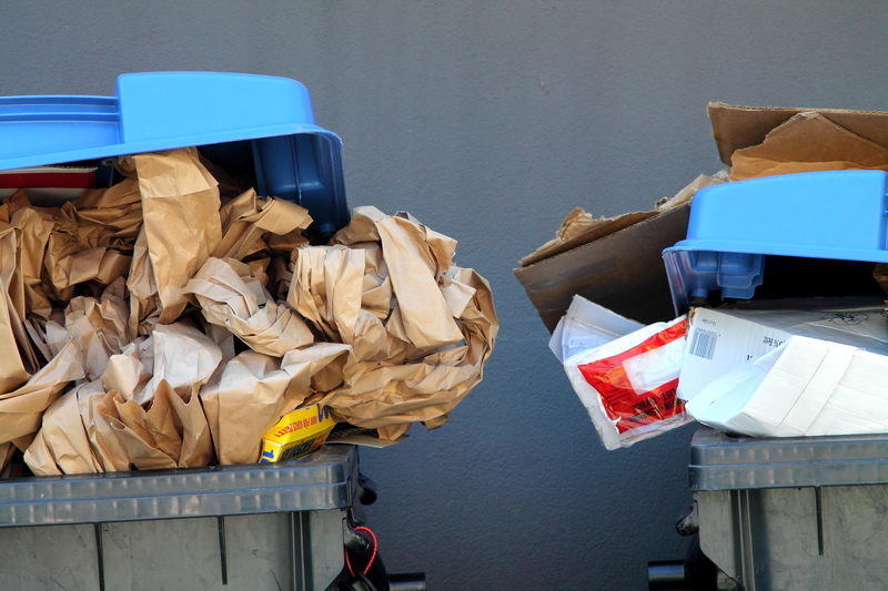 Recycling bins full with paper, cardboard and other materials.