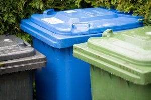 Recycling and waste bins outside.