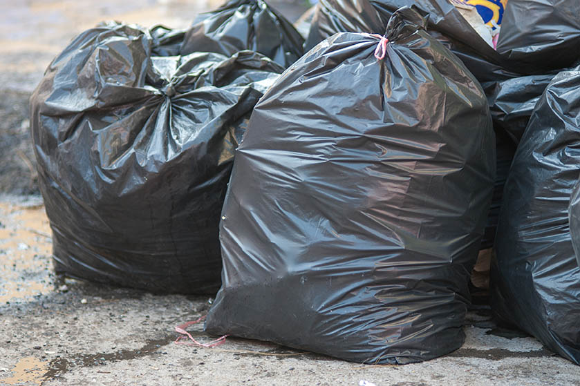 Garbage bags piled on a street.