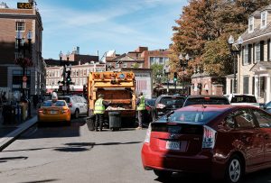 Waste collection truck on city street in Massachusetts.