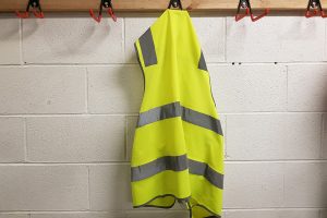 A yellow safety vest hanging at a workplace.