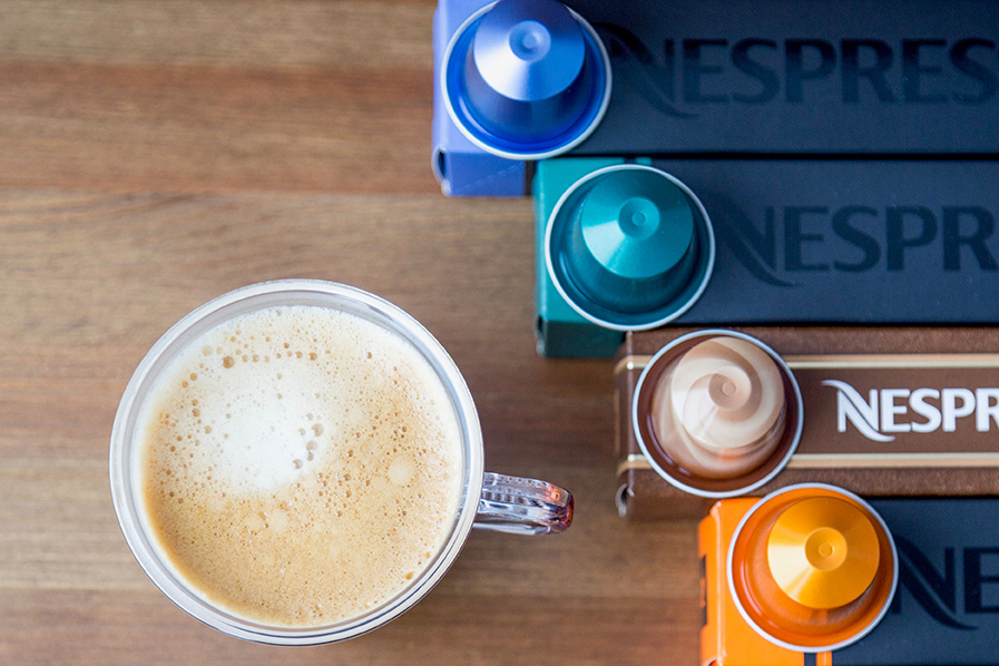 Cup of coffee with various Nespresso coffee capsules.