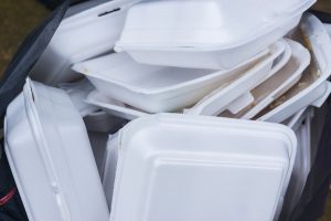 Many polystyrene takeout containers in a waste bin.