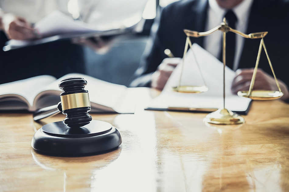 Court gavel and justice scales on a table.