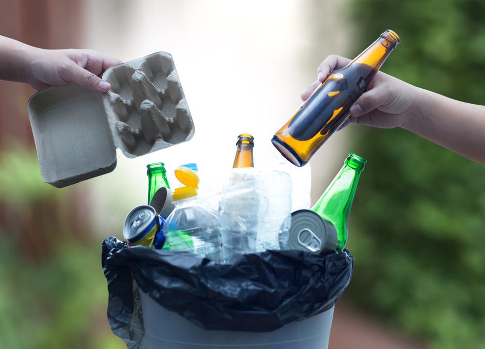 Handing materials into a recycling bin.