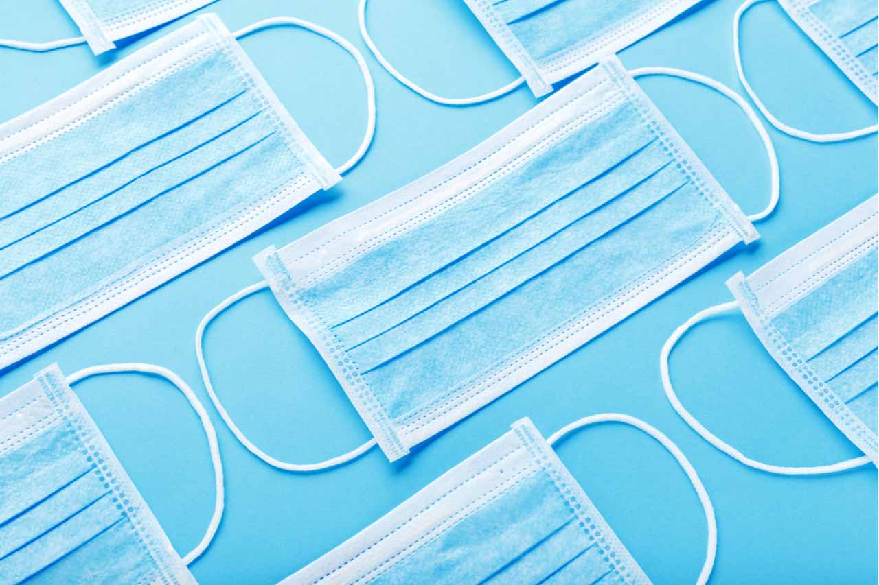 Medical masks arranged on a blue background.