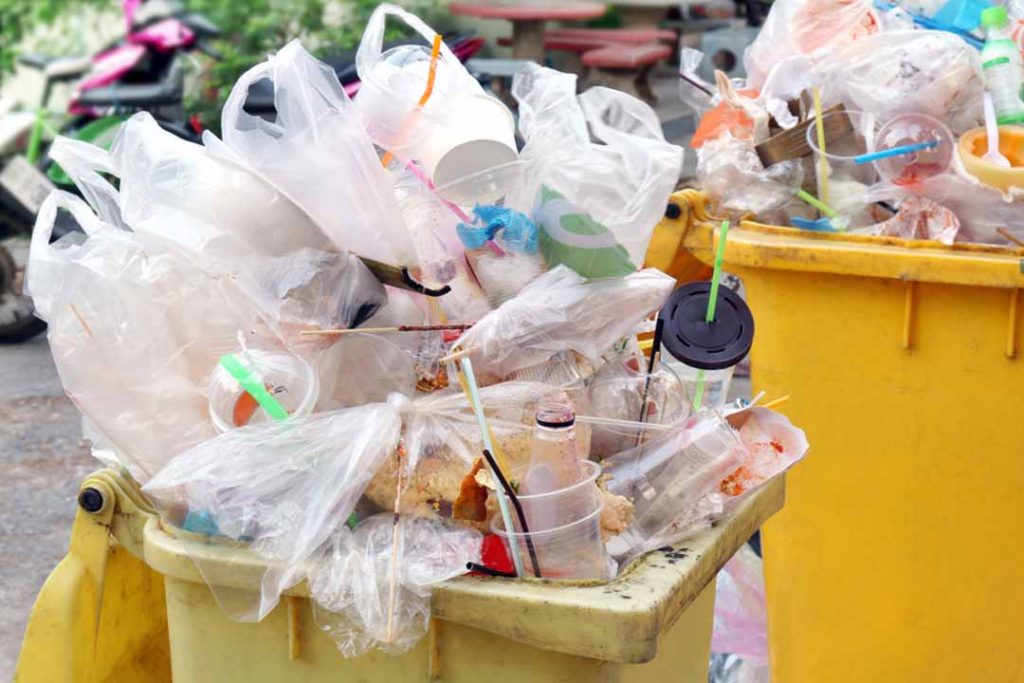Plastic waste collected piled high in a trash bin.