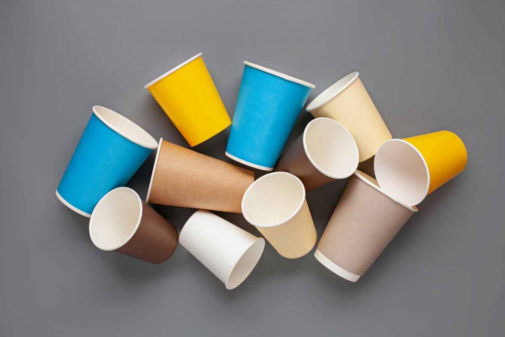 Colorful paper coffee cups on a gray background.