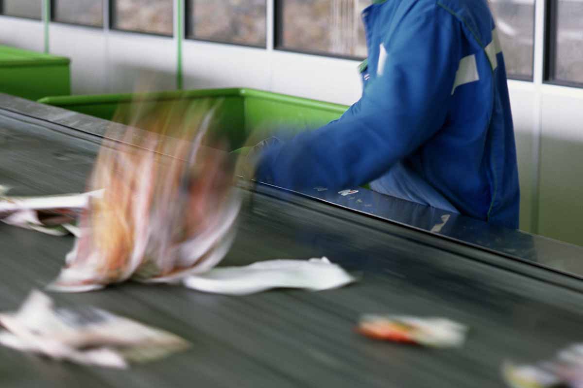 Staff picks material off the sort line in a materials processing facility.