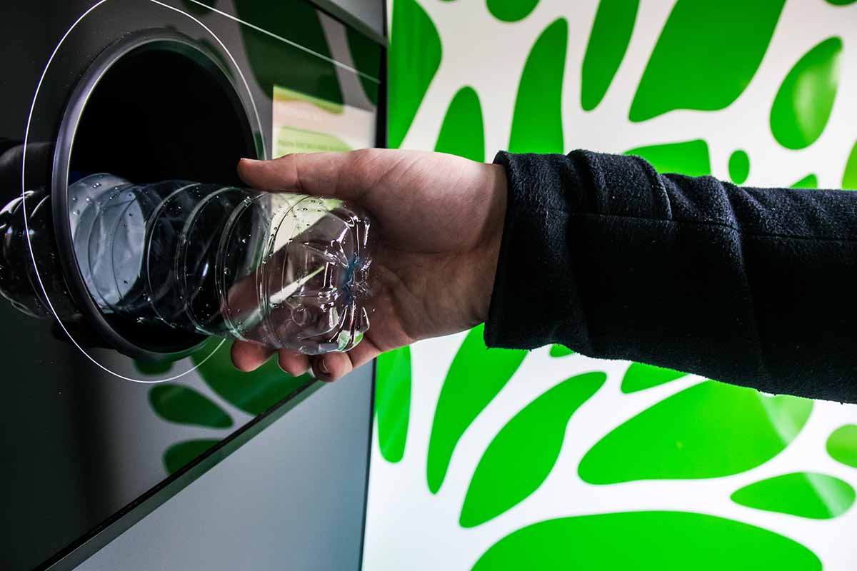 Returning a plastic beverage bottle for deposit at a reverse vending machine.