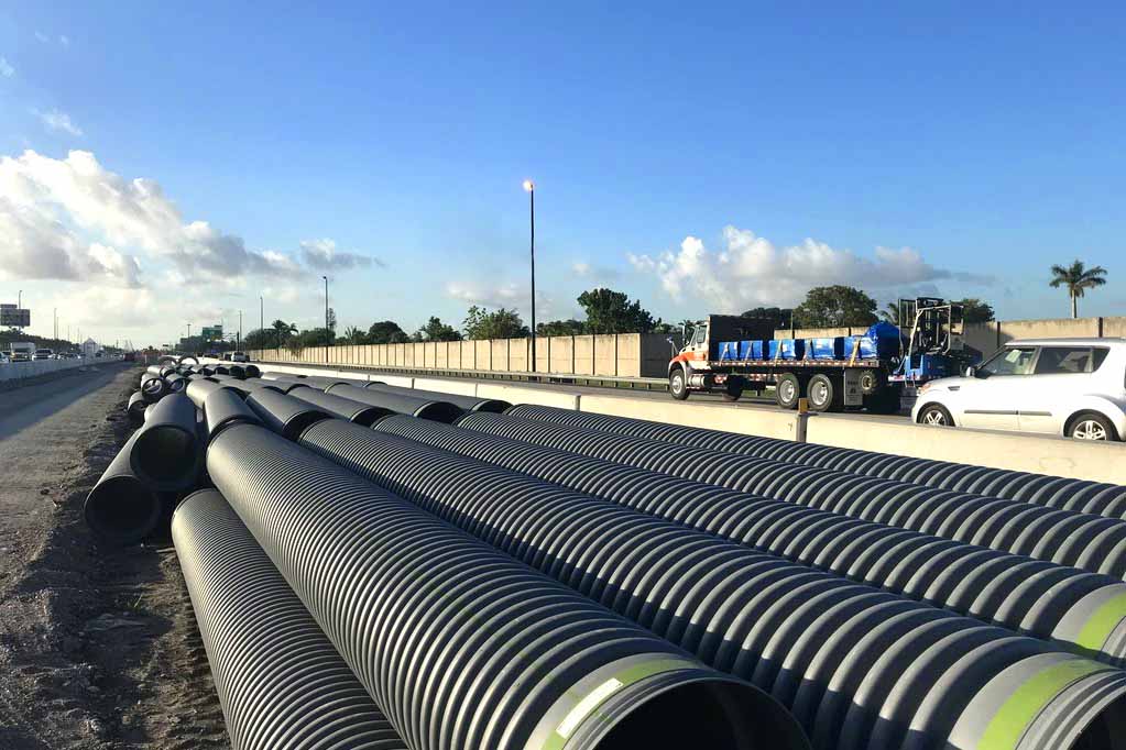 ADS pipe stacked for highway drainage installation.